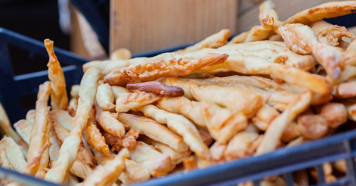 Delicious golden brown breadsticks neatly arranged in a basket, showcasing a perfect snack or appetizer.