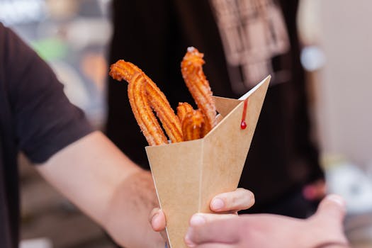 Delicious churros served in a paper cone, perfect for a sweet street food snack.