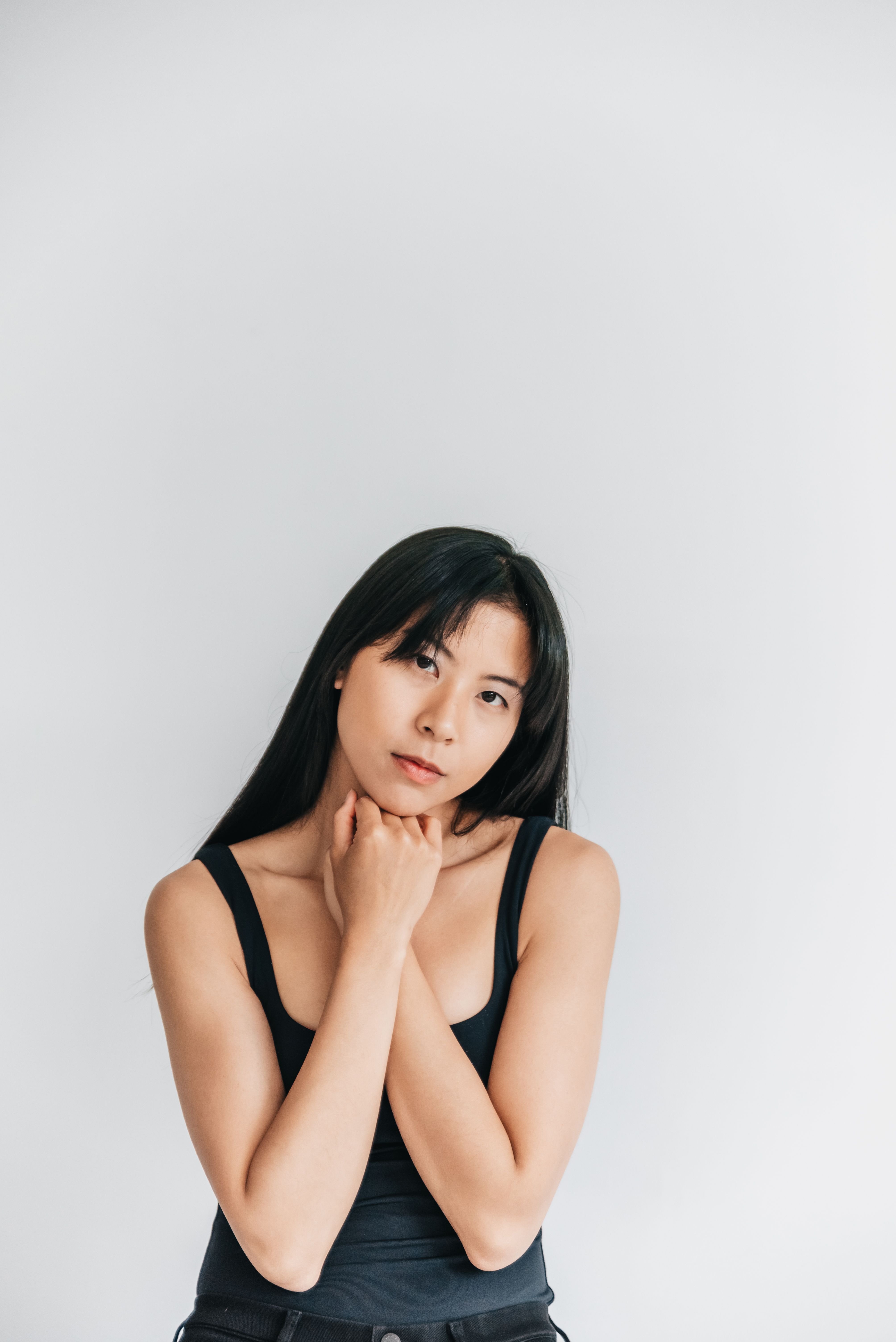 Elegant portrait of a woman posing thoughtfully in a studio setting.