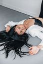 Woman in White Long Sleeve Shirt Lying on Floor