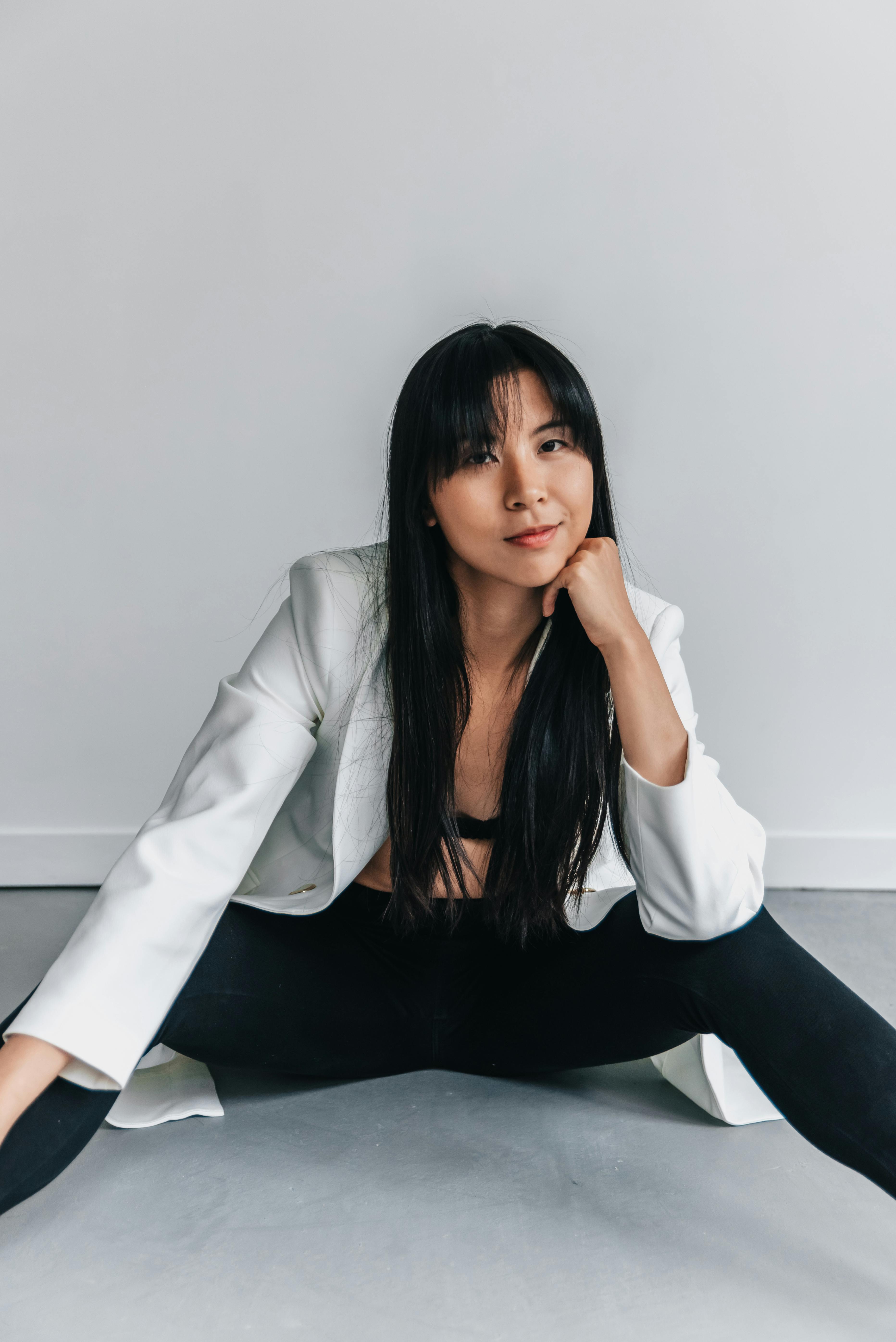 a woman in white unbutton coat posing for the camera