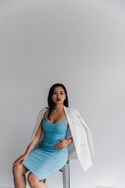 A Woman in Blue Dress Sitting on a Chair