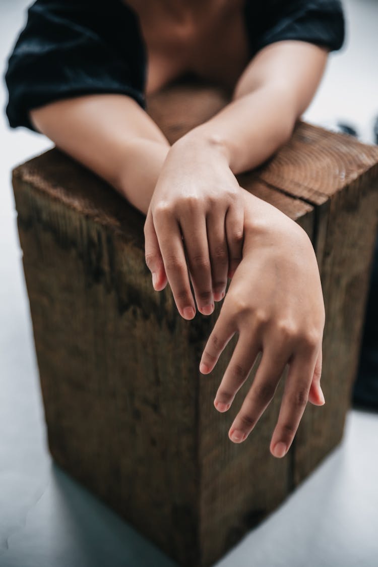 A Person Hand Over A Block Of Wood