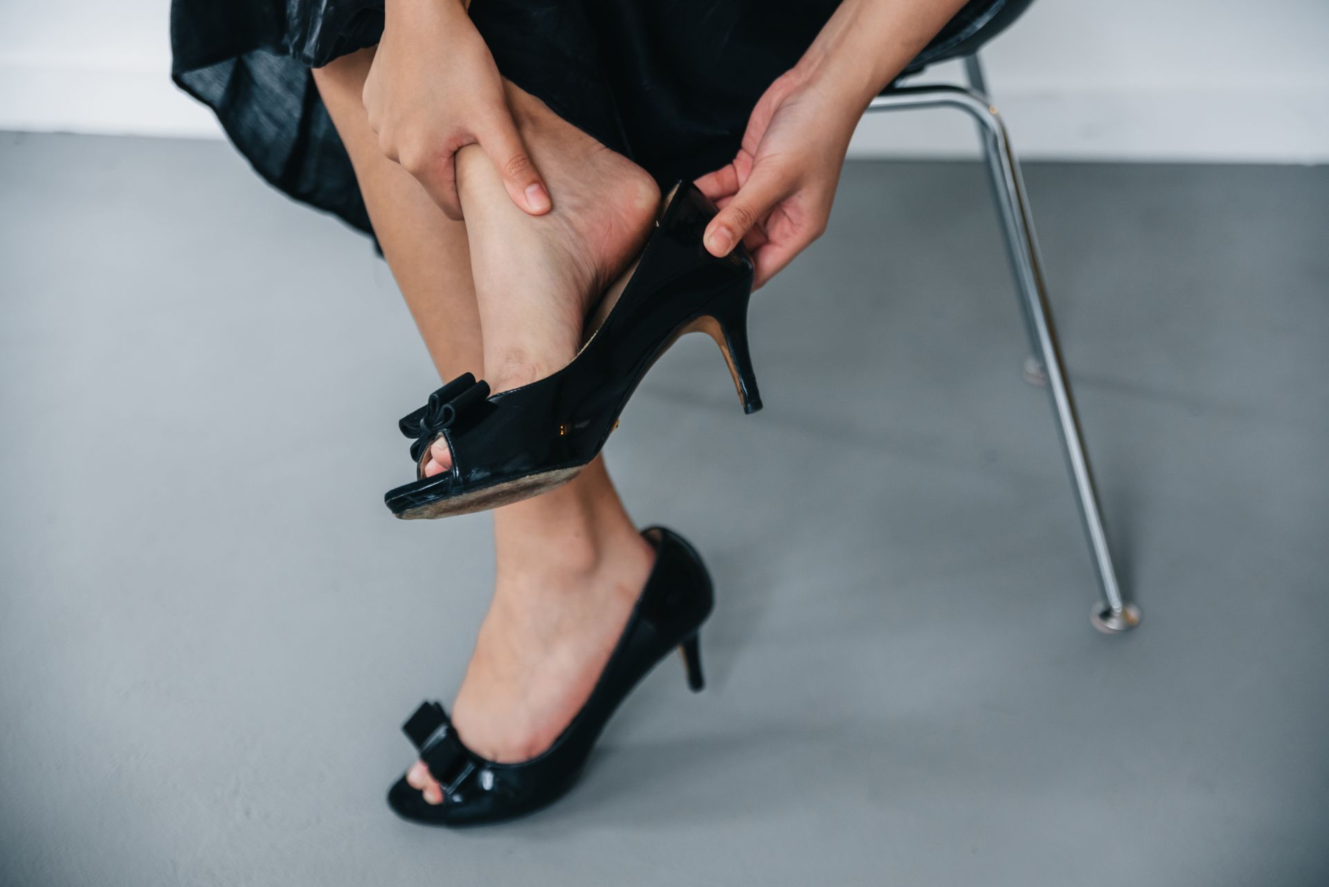 Photo of a Person Removing a Black Shoe