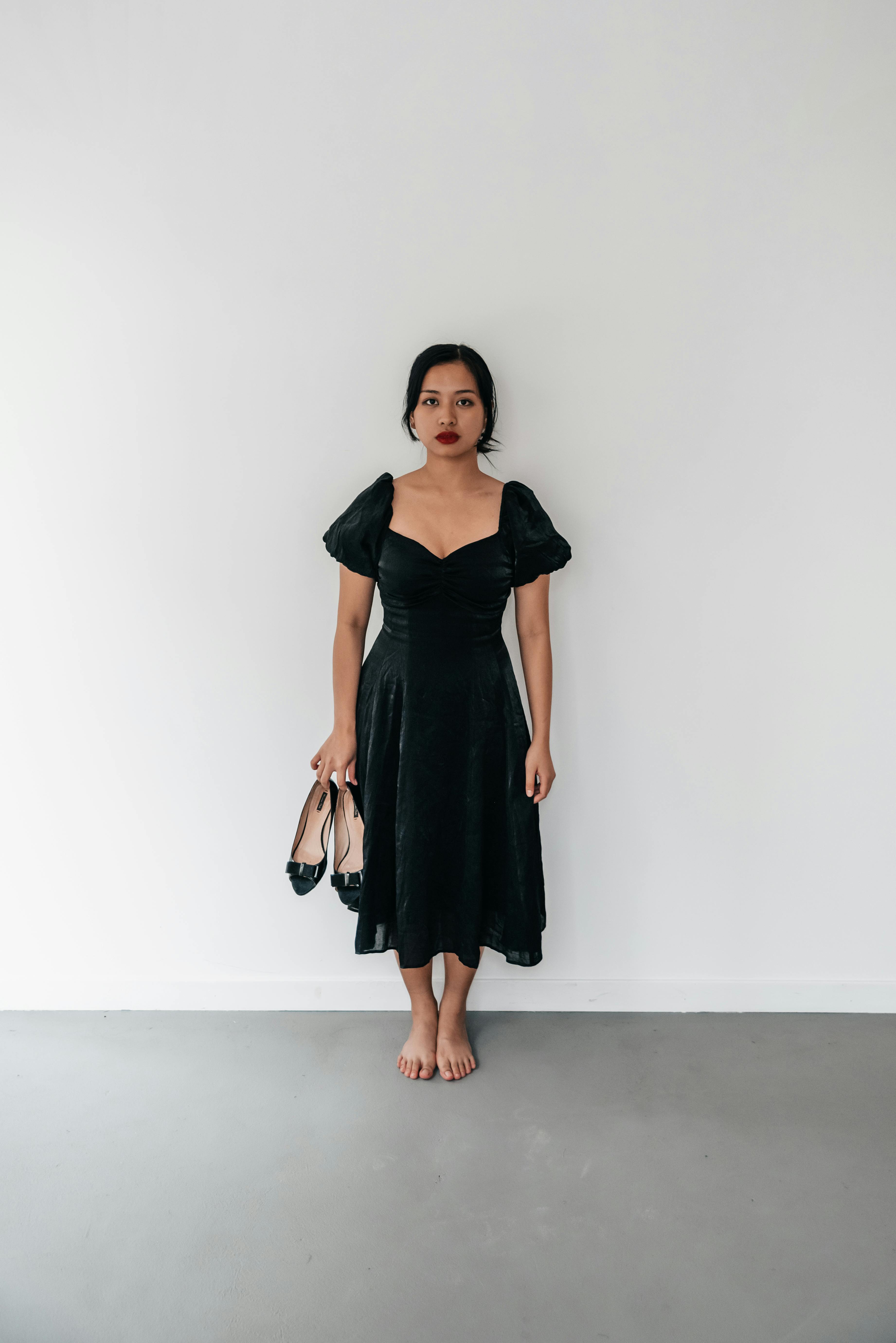 A woman in a black dress holding a black bag photo – With child