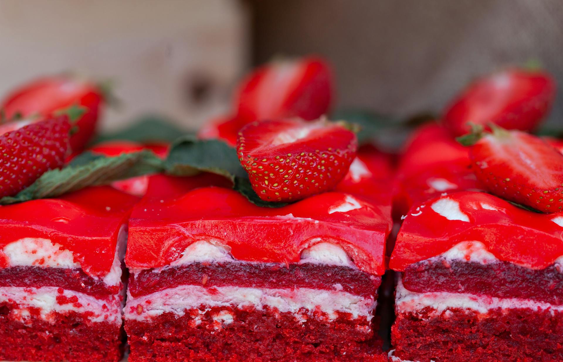 Delicious red velvet cake topped with fresh strawberries and cream, perfect for a sweet treat.
