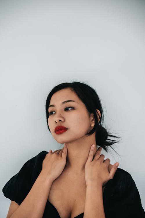 Free Photo of a Beautiful Woman in Red Lipstick Posing with Her Hands on Her Neck Stock Photo