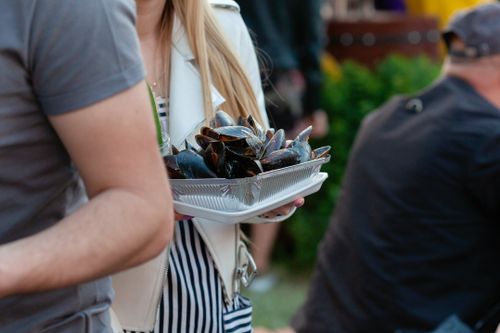 Free Plate of mussels being carried at an outdoor food event. Stock Photo