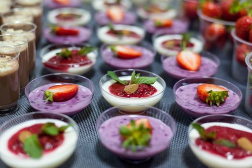 Free A variety of panna cotta desserts topped with fresh strawberries and mint leaves, creating a vibrant and sweet presentation. Stock Photo