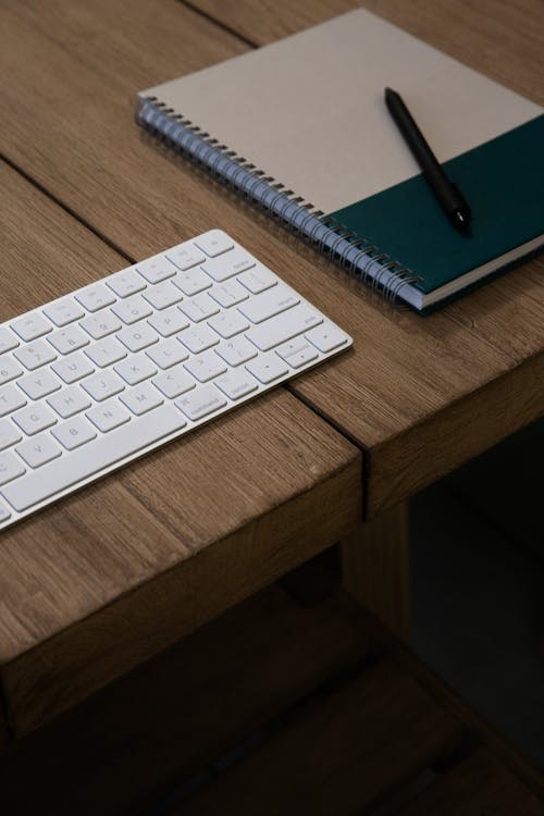 Free Apple Keyboard on Brown Wooden Table Stock Photo