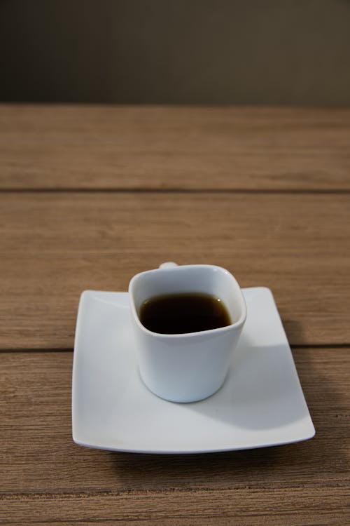 Free Ceramic Cup with Black Tea on a White Ceramic Saucer Stock Photo