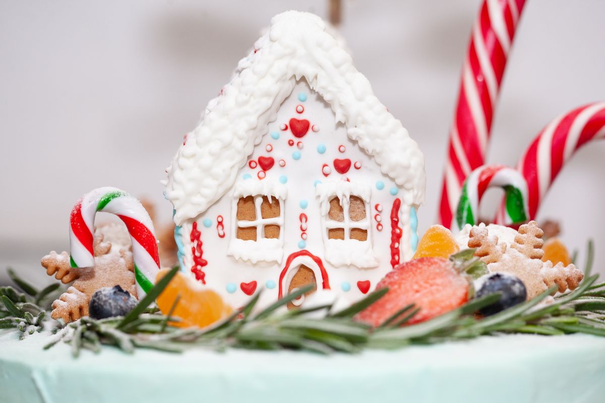Close-up of a colorful gingerbread house adorned with candy canes and festive sweets, perfect for holiday themes.