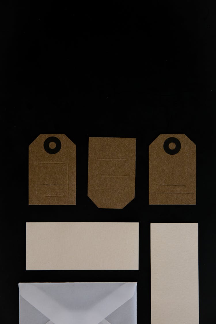 Brown And White Paper Tags Over A Black Surface