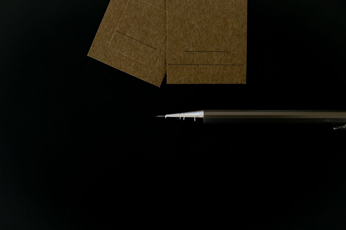 Blank business cards and a mechanical pencil on a black surface — photo by PNW Production on Pexels