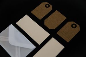Envelopes and tags on a dark surface, by PNW Production on Pexels