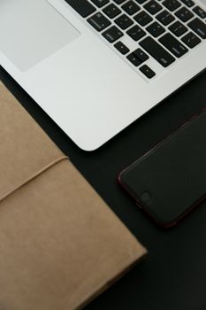 A clean and organized workspace featuring a laptop, notebook, and smartphone with a minimalist aesthetic.