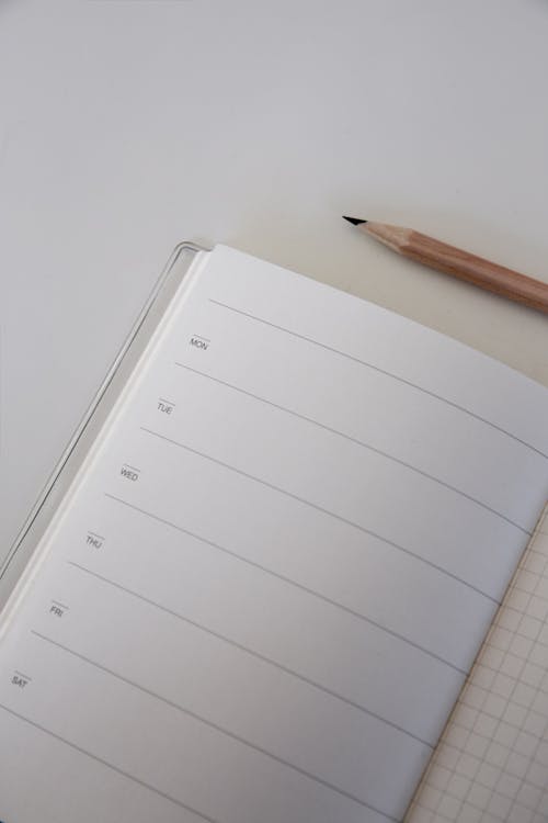 A Brown Pencil Beside a Journal