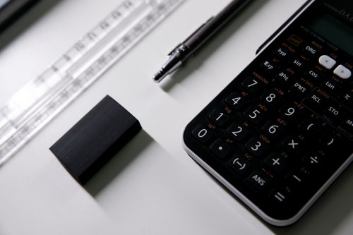 Free Close-up of a scientific calculator, ruler, and eraser on a desk, ideal for math or exam study visuals. Stock Photo