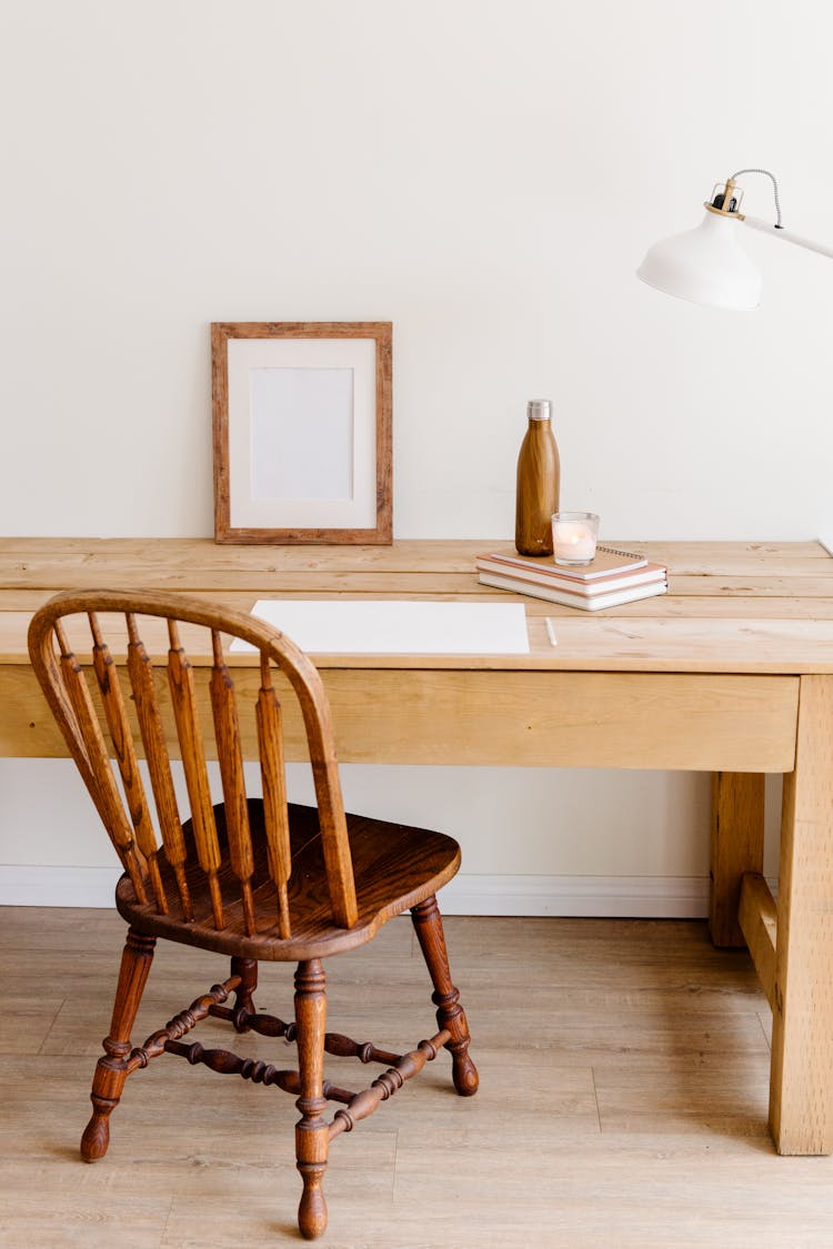 A Wooden Chair Near Notebooks On A Wooden Table