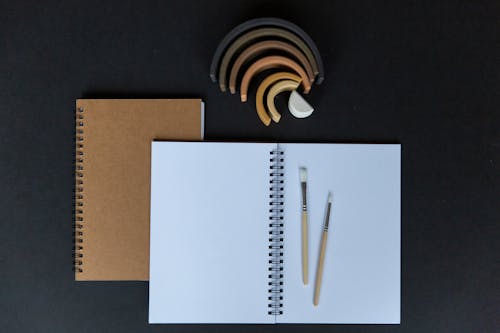 Free Open Notebook with Blank Pages and Paint Brushes  Stock Photo