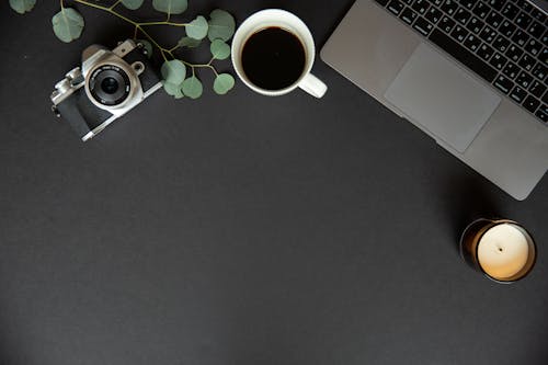 Top View of Still Life with an Analogue Camera and Modern Laptop