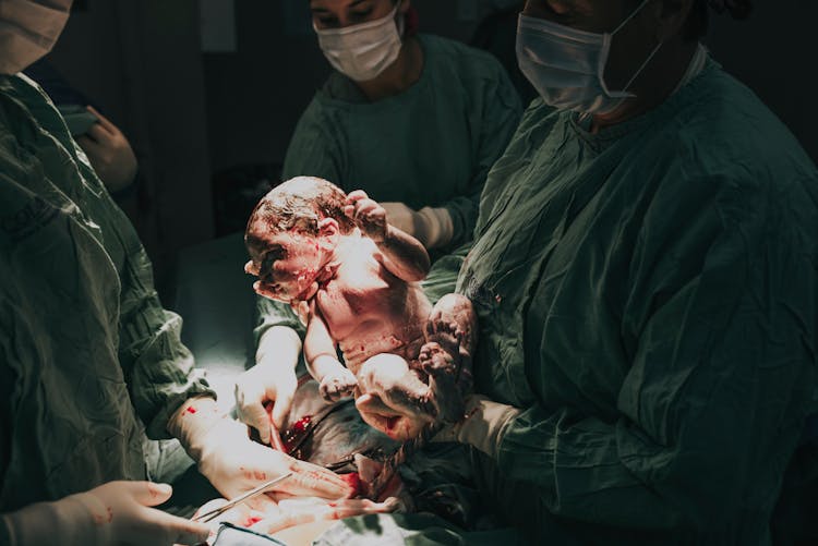 Doctor Holding Newborn After C-Section