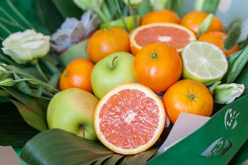 Photo of a Sliced Grapefruit Near Green Apples