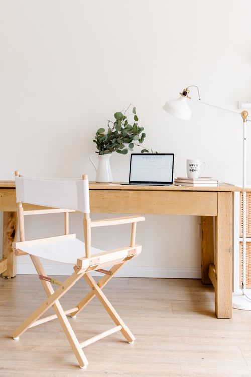 Free Contemporary minimalist home office featuring a wooden desk, chair, and laptop setup for productivity. Stock Photo