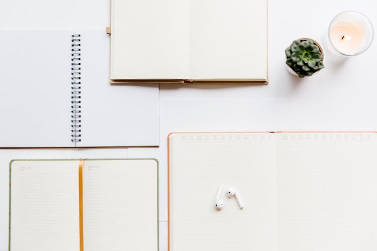 Overhead Shot Of Planners Near A Candle