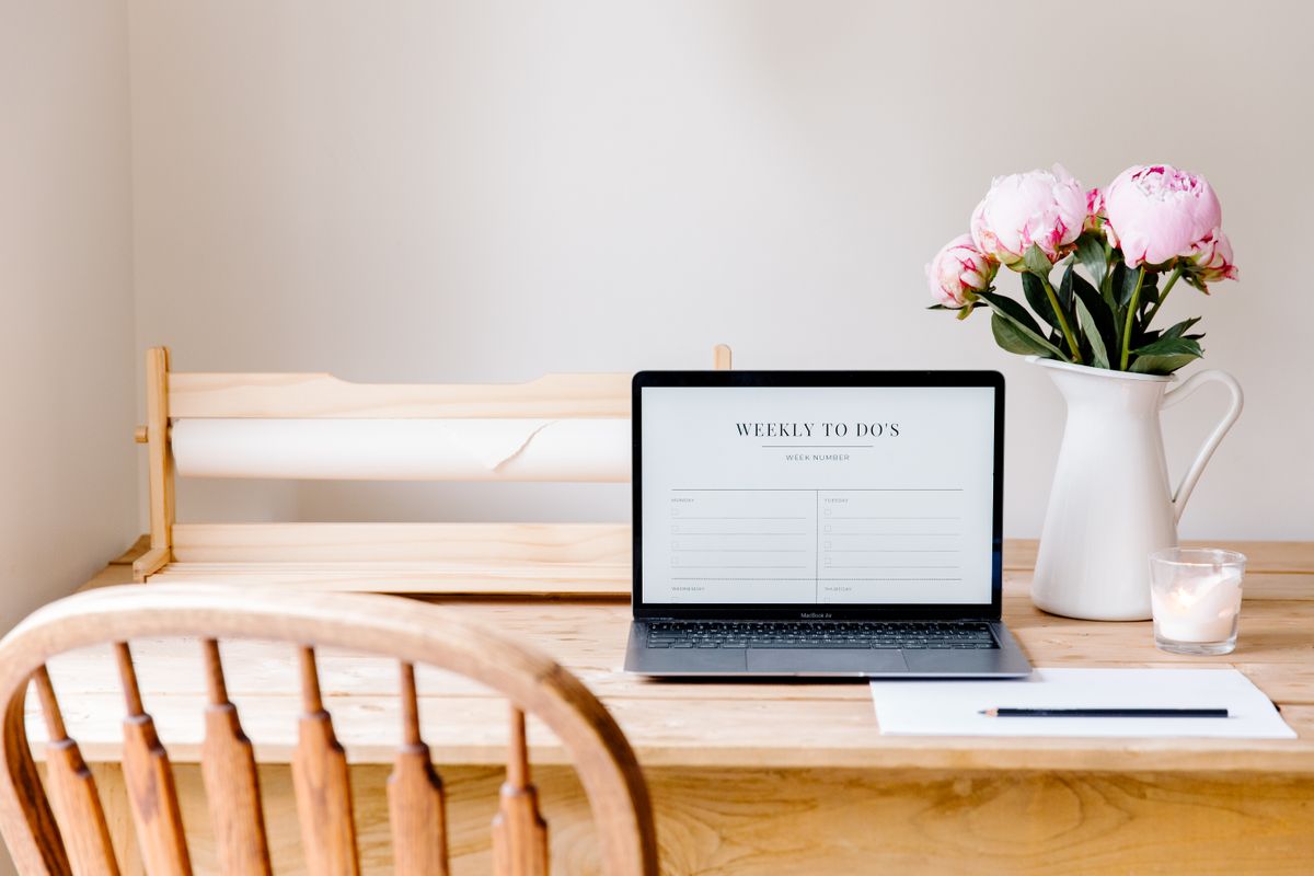 Wedding planner elegant workspace with laptop and fresh flowers on white desk London