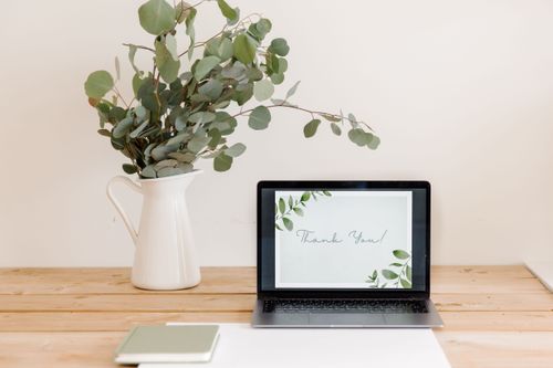 Free A stylish workspace featuring eucalyptus in a vase and a laptop displaying a thank you message. Stock Photo