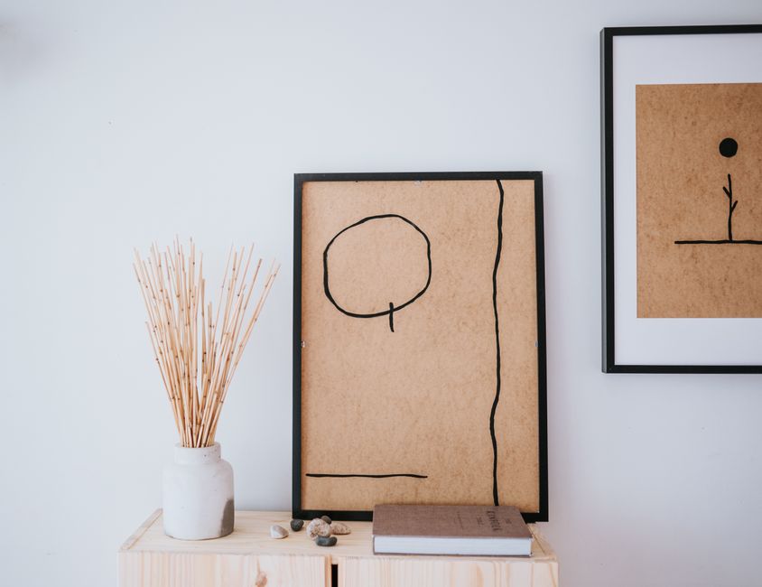A minimalist Japandi-style bedroom with greige walls, low-profile wooden bed frame, and soft linen bedding