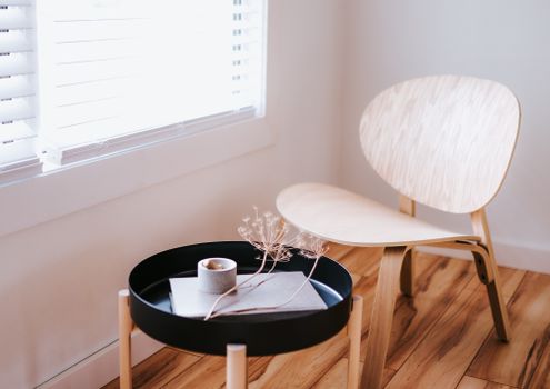 Elegant Japandi style room with a wooden chair, round table, and decorative items.