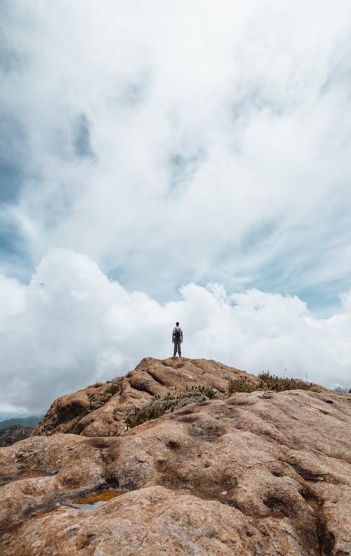 A Man Standing on Brown Rock Formation