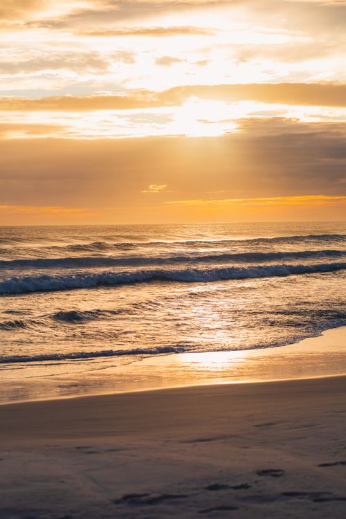 Free Gorgeous sunset view over the serene beach in Arraial do Cabo, Brazil, with golden skies and gentle waves. Stock Photo