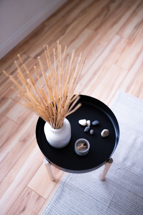 Free Round table with minimalist decor in Japandi style, featuring vase with sticks and stones. Stock Photo