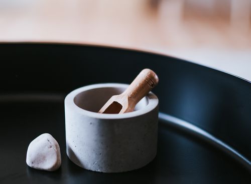 Free Minimalist kitchen decor showcasing a stone bowl and wooden scoop on a black tray. Stock Photo