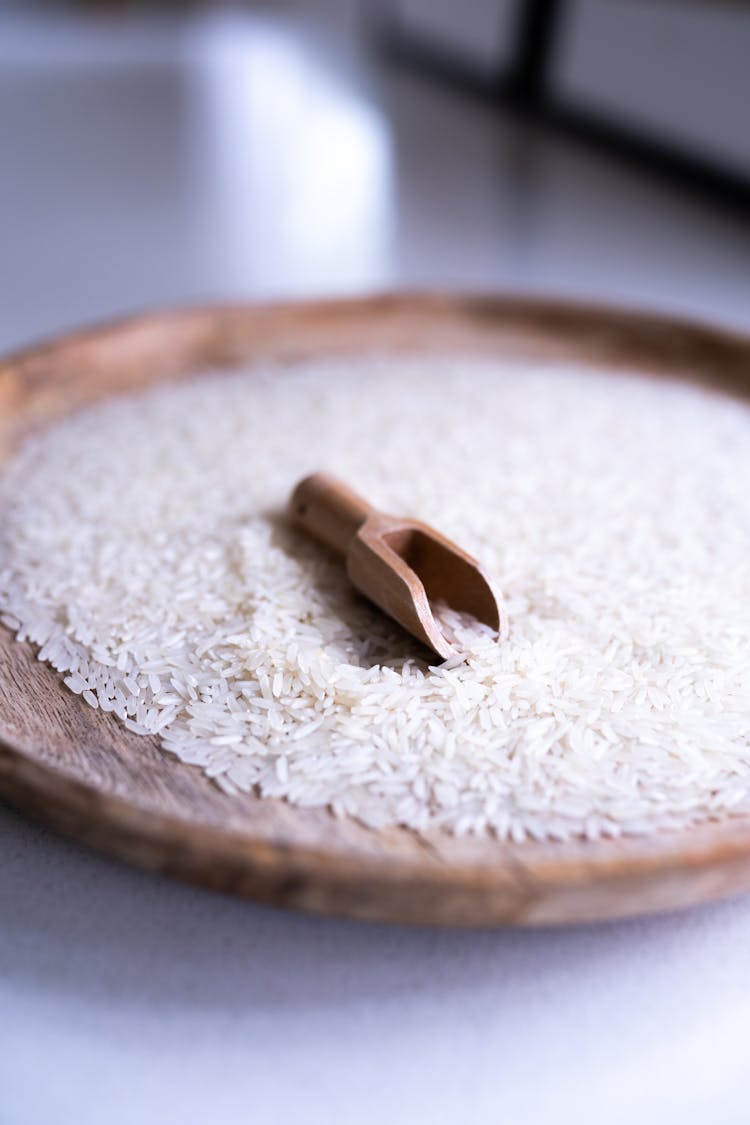 White Rice Grains With Brown Wooden Shovel