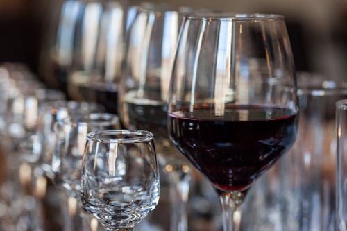 Rows of Smaller and Bigger Wineglasses with Red Wine