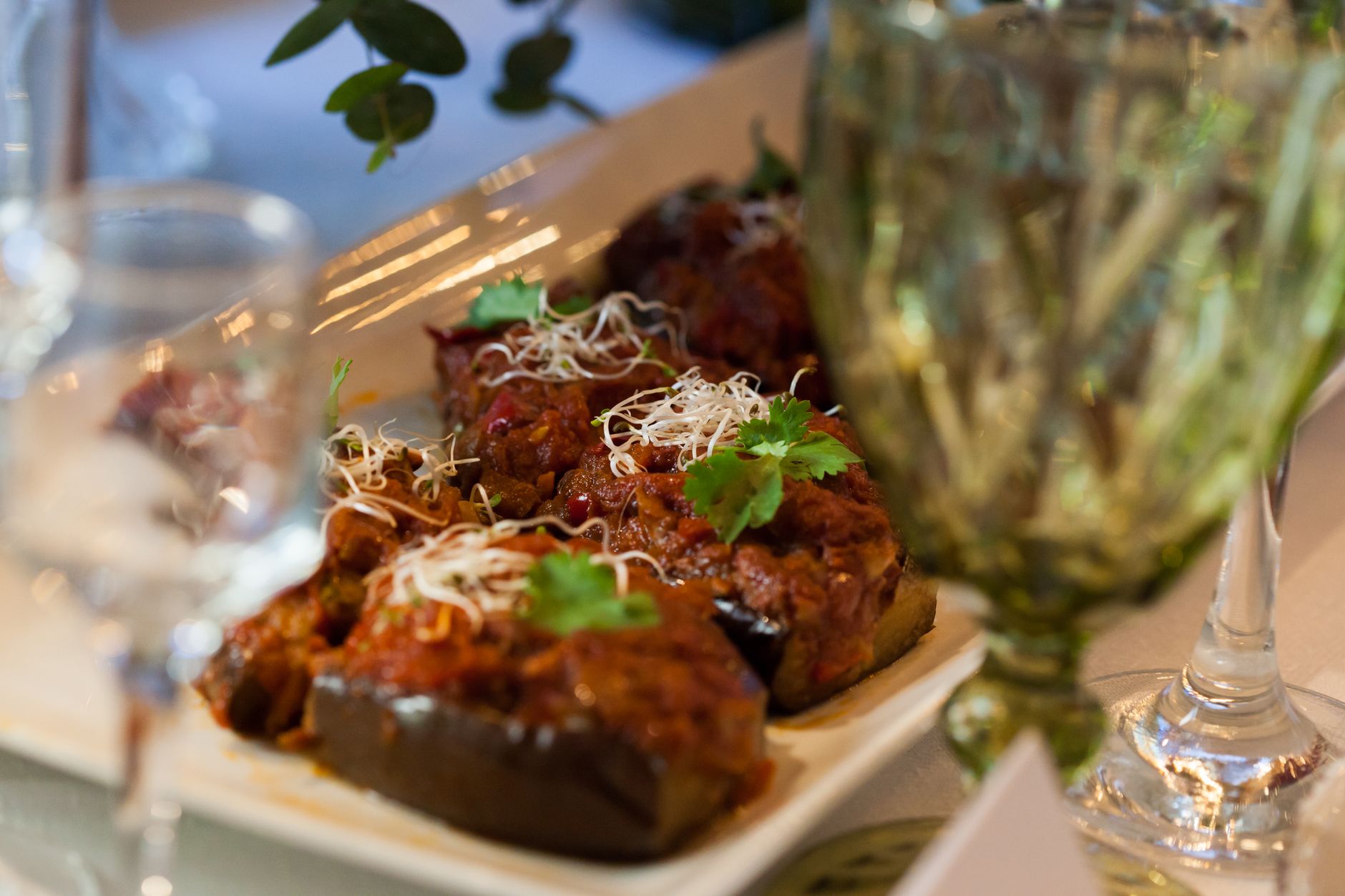 Delicious stuffed eggplants garnished with cilantro in a cozy restaurant setting.