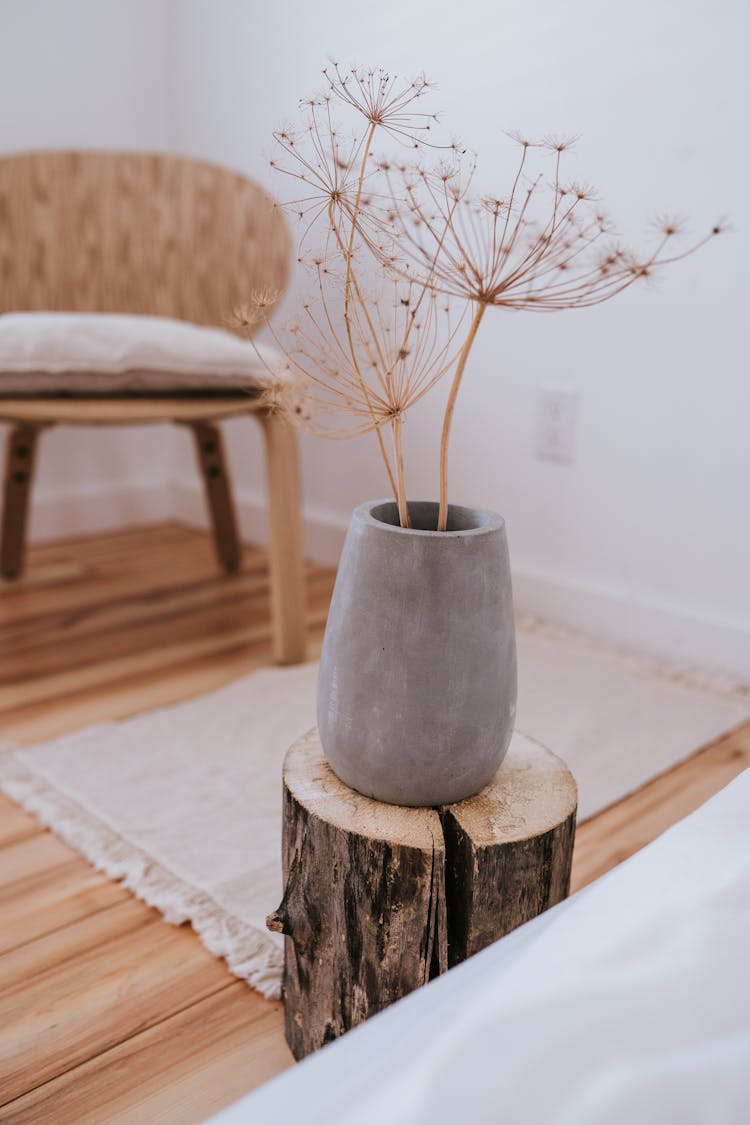 Gray Pot With Flowers On Chopped Wooden Log