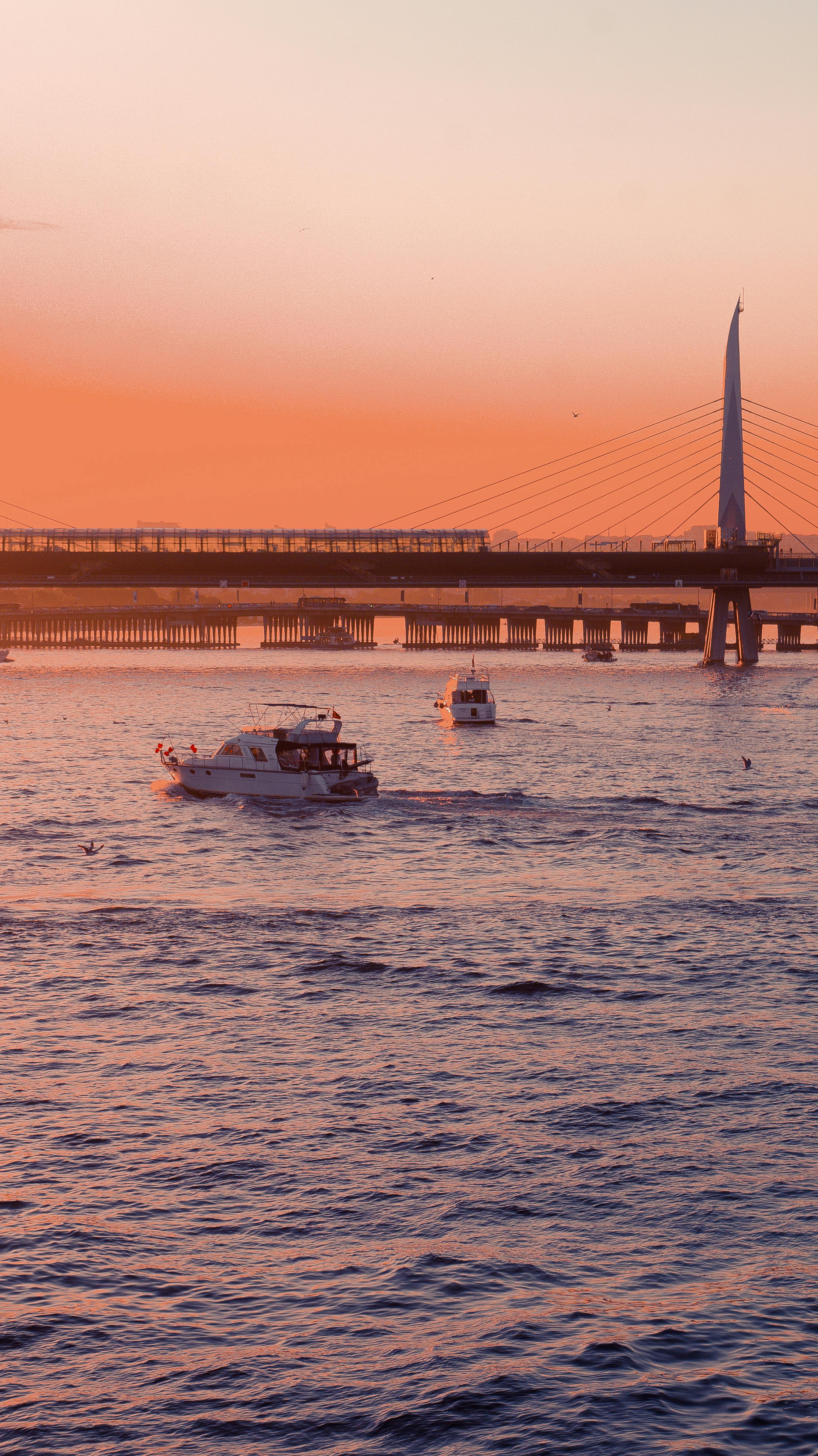 Tranquil sunset view of boats and Halic Metro Bridge in Istanbul, Turkey.