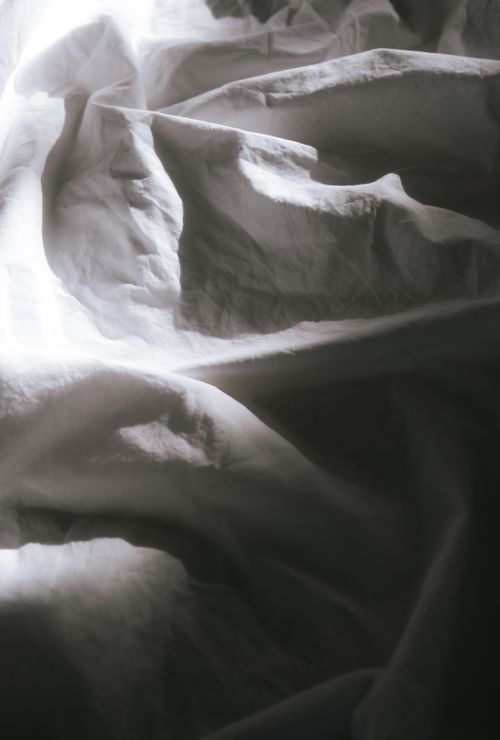 Free A detailed and artistic capture of wrinkled white fabric with soft, natural lighting. Stock Photo