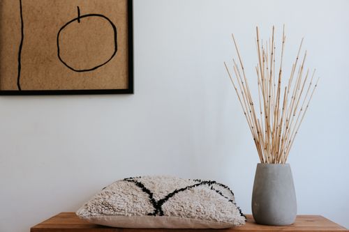 Free Modern Japandi interior with ceramic vase, cushion, and abstract art for a serene home decor theme. Stock Photo
