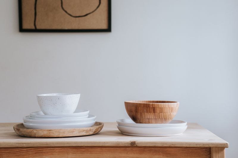 White and wooden bowls arranged on a wooden table — photo by PNW Production on Pexels