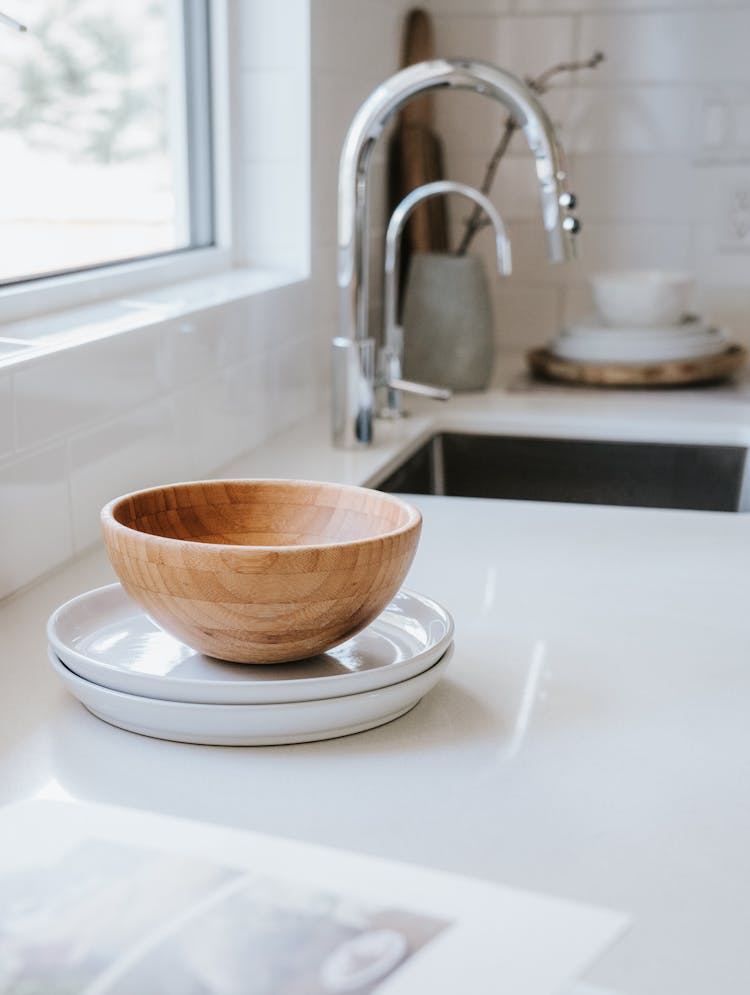 A Wooden Bowl On A Ceramic Plates