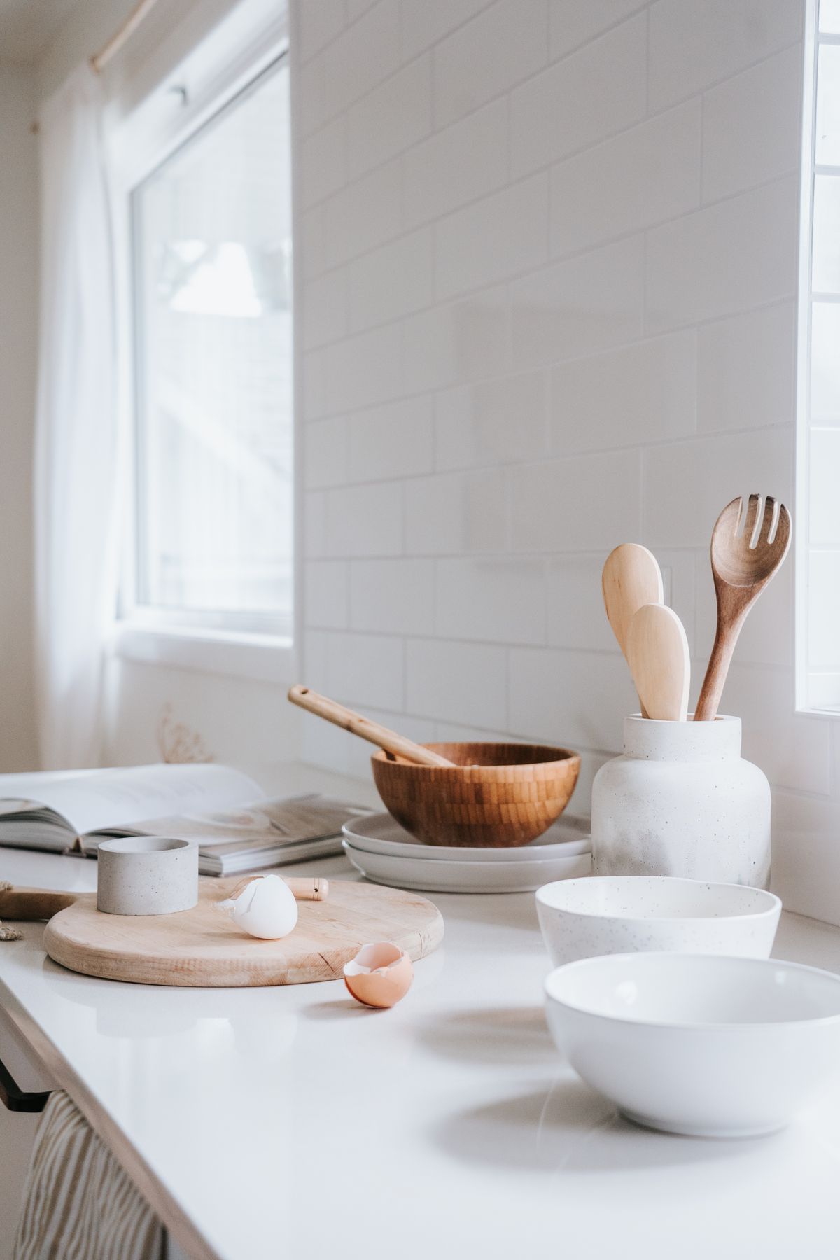 Bright minimalist kitchen with ceramic tableware and wooden utensils