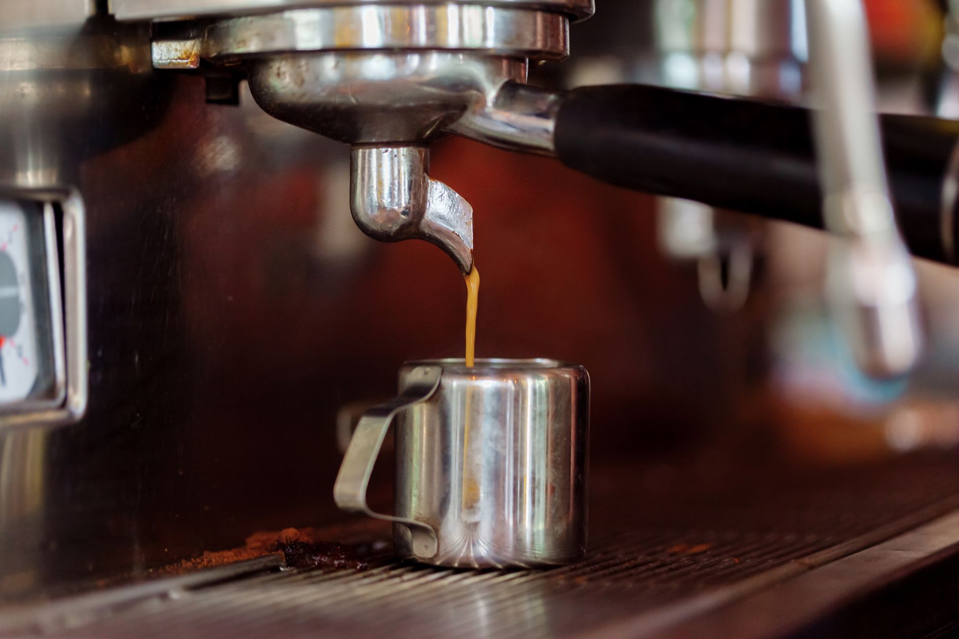 Close-up of espresso being brewed in a café setting with a coffee machine.