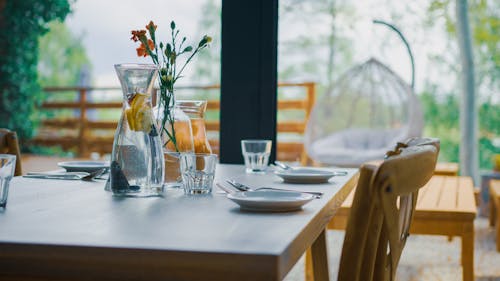 Flowers in Vase and Plates on Table