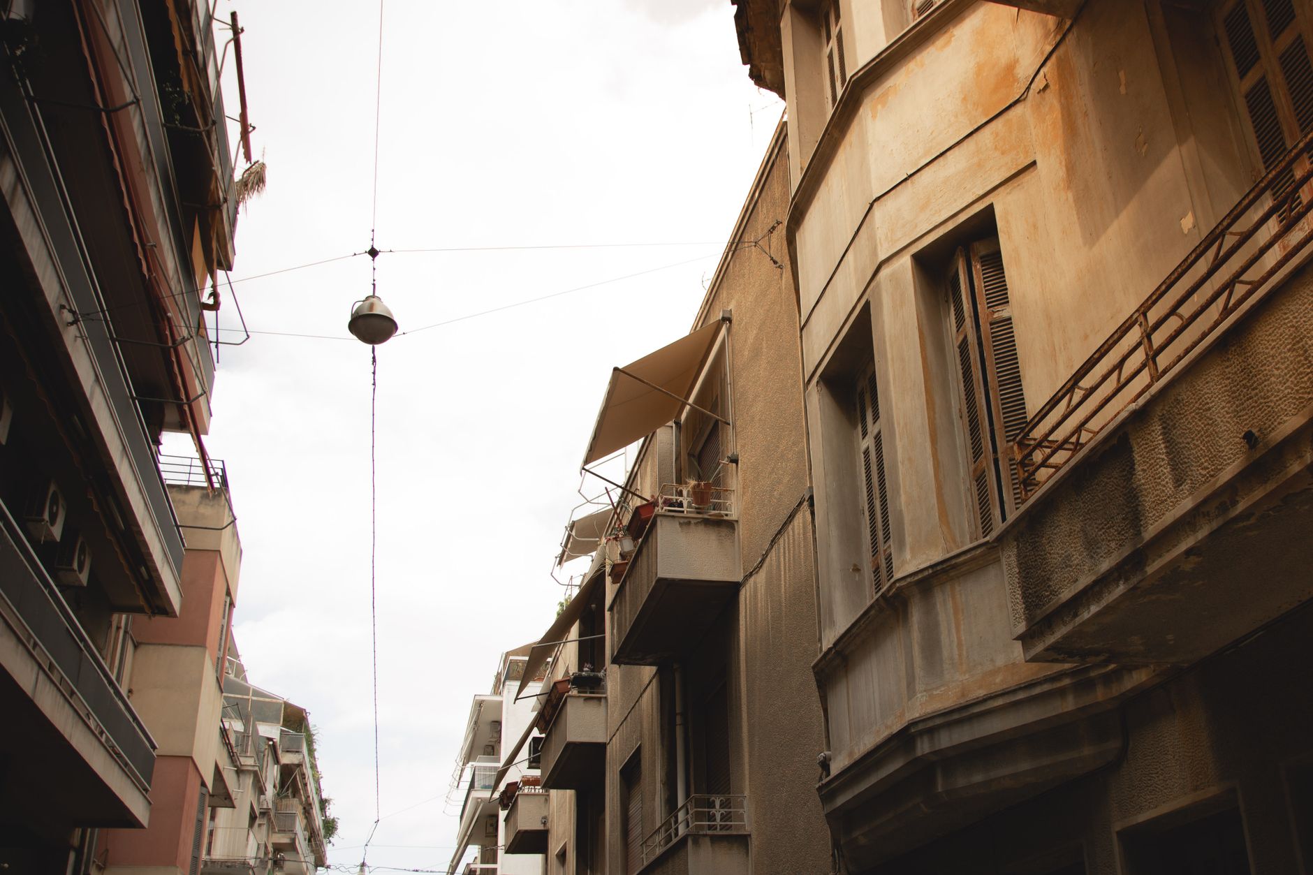 Explore the classic urban architecture and residential buildings in a Greek city, highlighting balconies and windows.